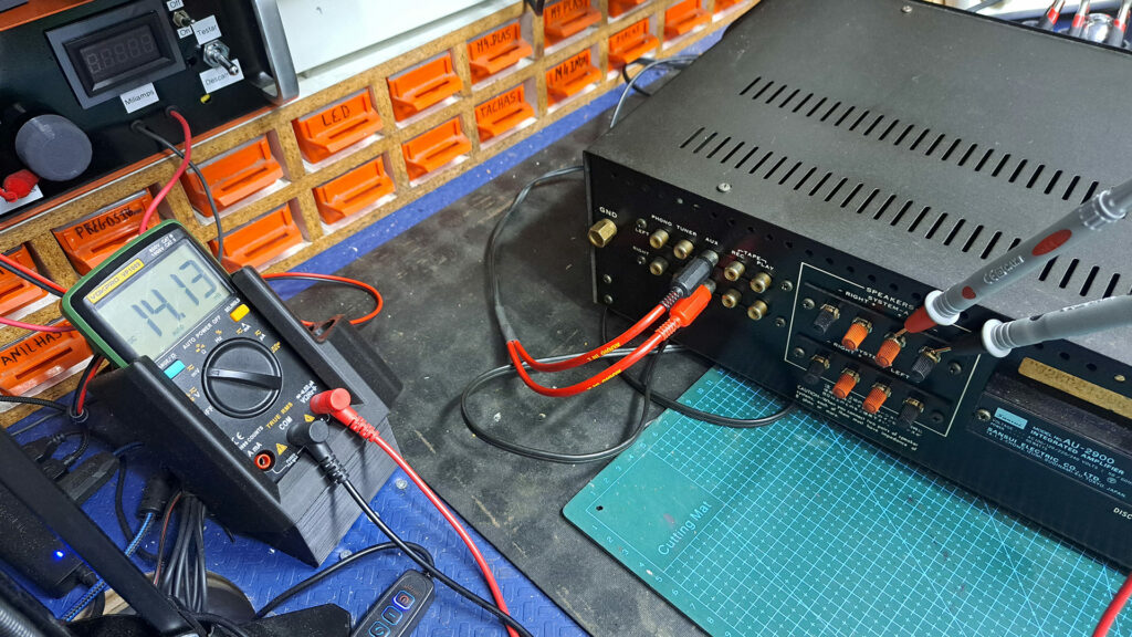 Amplificador Sansui AU-2900, colocado em cima de uma bancada de reparo, a ser verificado